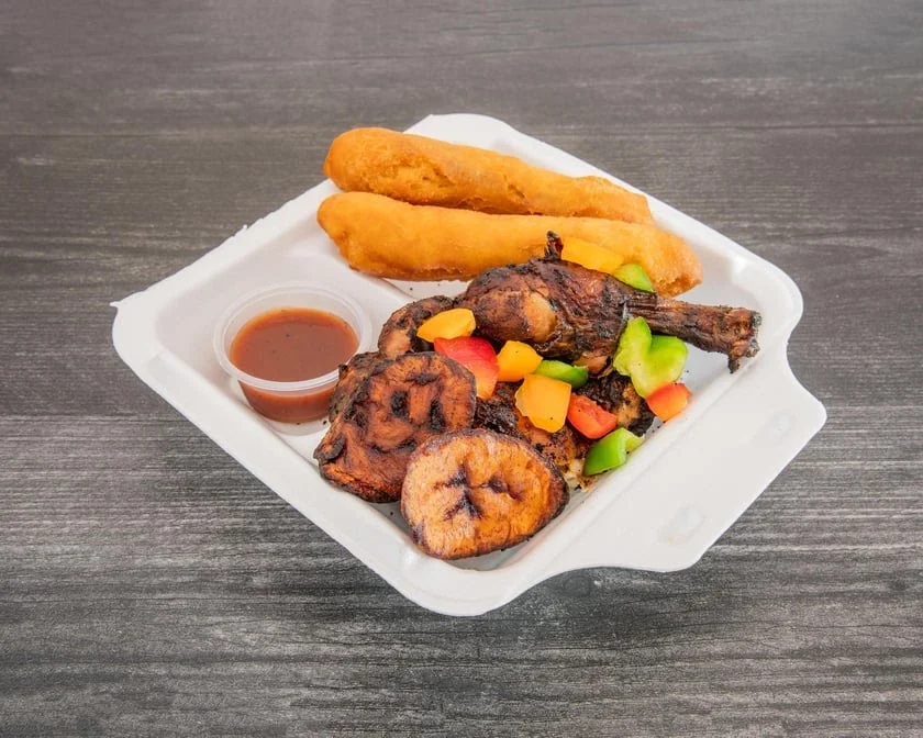 Flame-grilled Jamaican jerk chicken plate served with rice and peas and steamed cabbage